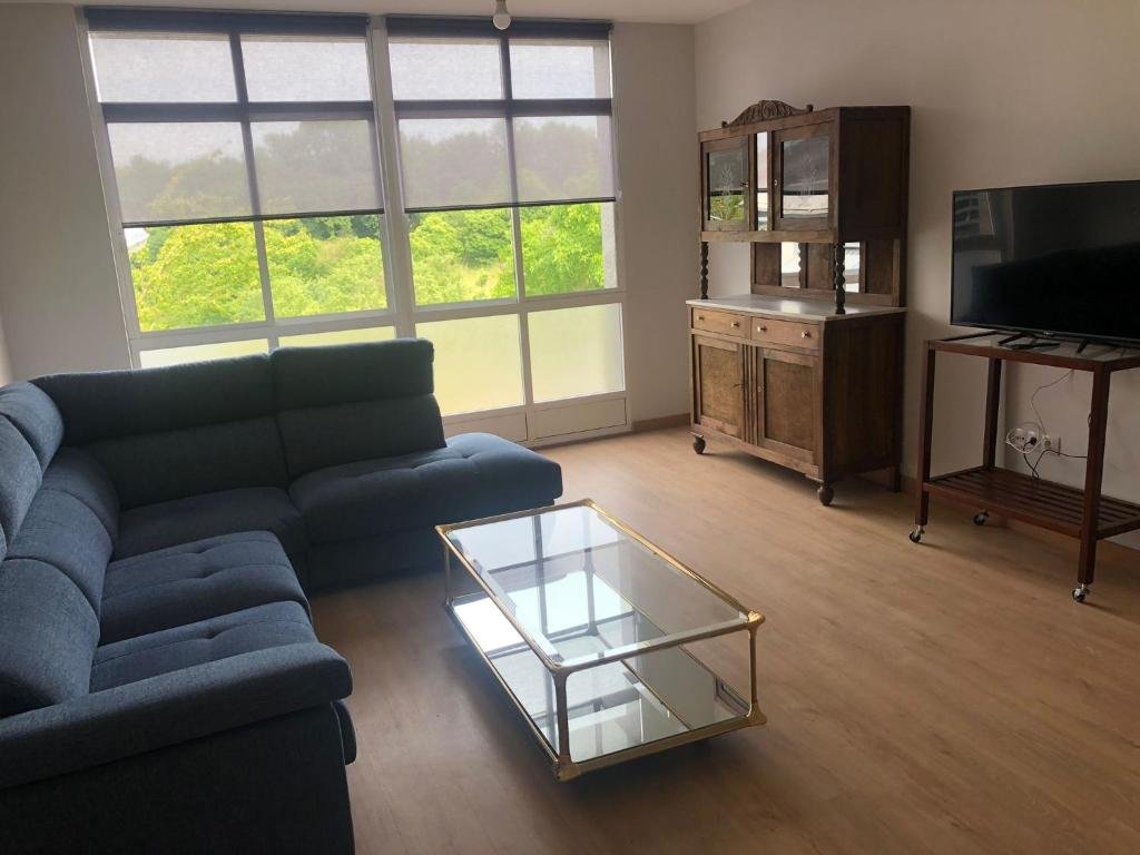 Salón con sofá azul y vistas al jardín